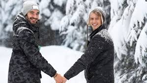 Two people holding hands in the snow.