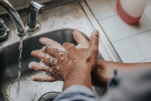 A person washing their hands in the sink.